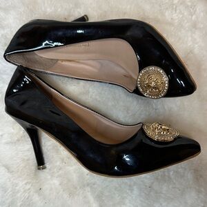 Zara Classic Black Patent Heels with Gold Medallion Accent.